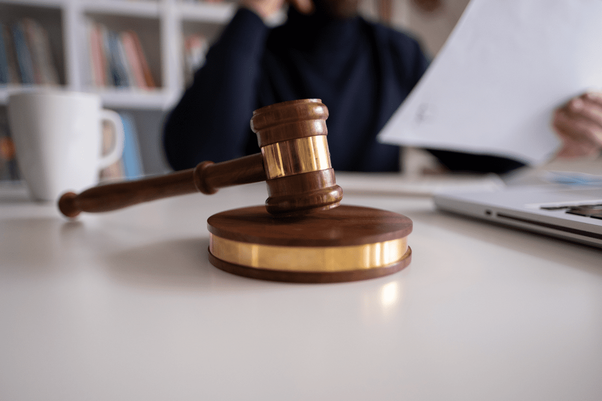 Gavel on desk with person in background.