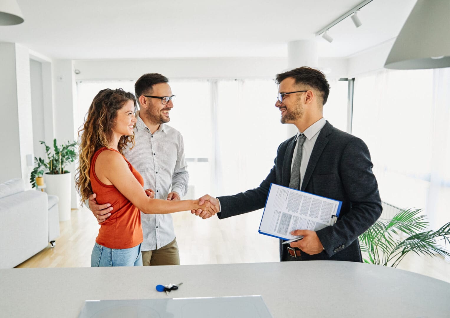 Couple shaking hands with real estate agent.