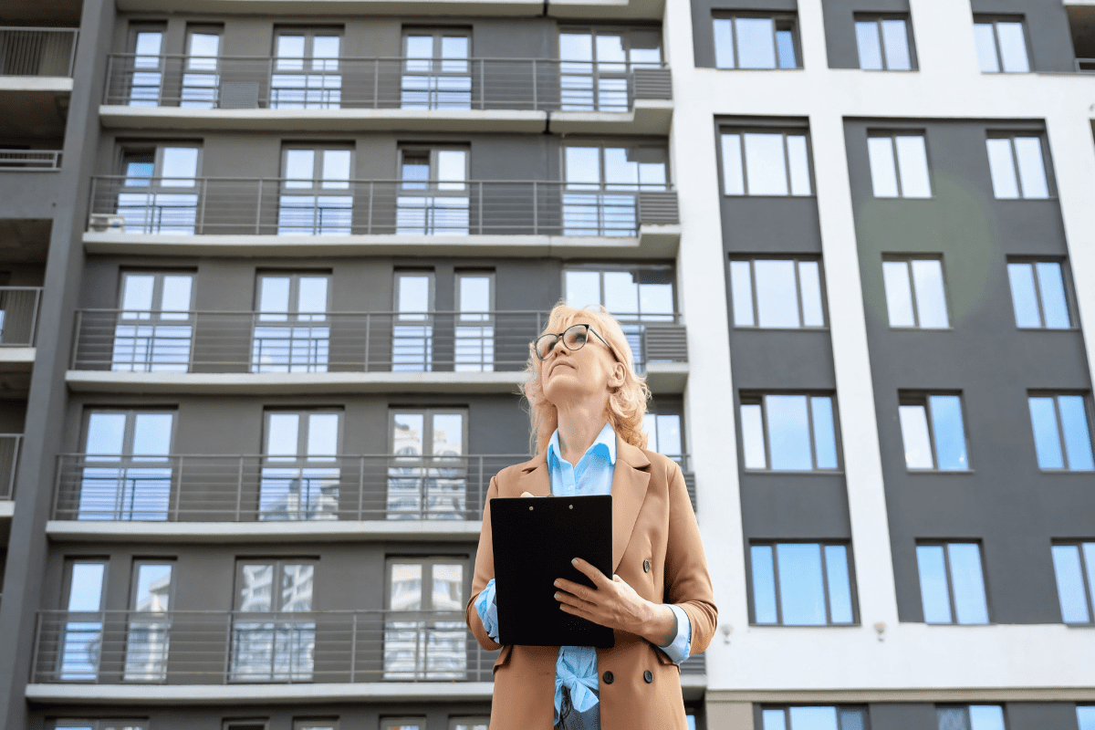 Woman inspecting modern apartment building exterior.